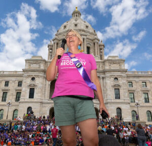 Wendy Jones with mic in hand speaking to a crowd